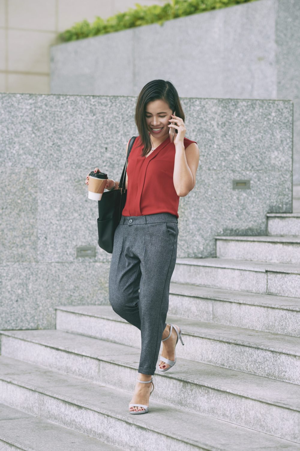 Beautiful female entrepreneur talking on phone when walking outdoors